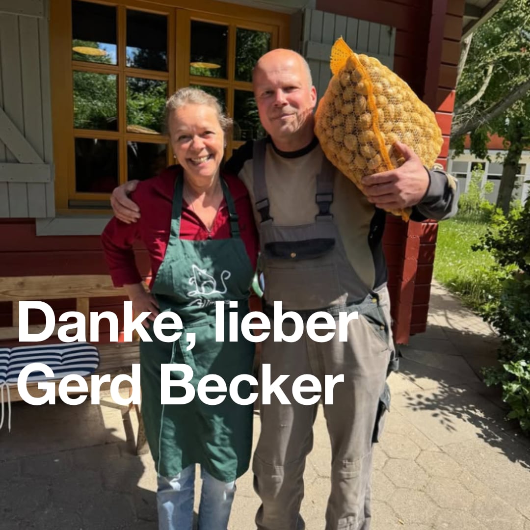 Bild zeigt zwei Personen, die in die Kamera lächeln. Eine Person hat einen großen Sack Kartoffeln auf der Schulter. Text: Danke, lieber Gerd Becker!