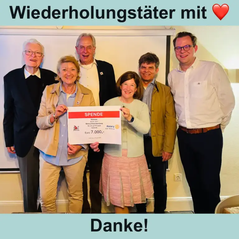 Das Bild zeigt sechs Menschen, die freundlich in die Kamera lächeln. Zwei Personen halten einen symbolischen Scheck über siebentausend Euro in der Hand. Zusätzlicher Text: Wiederholungstäter mit Herz. Danke!